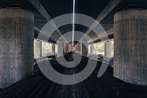 Some thick pillars stand under highway bridge