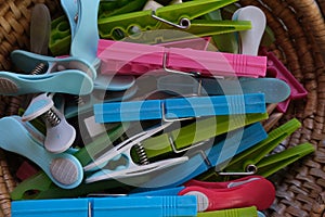 Some types of colored clothespins, to hang clothes in a wicker basket