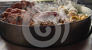Some types of meats and vegetables being coocked on a grill of a reustarant. photo