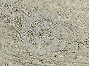 Some tyre prints and footprints on dusty road on crime scene