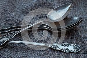 Some vintage silver spoons on rough fabric