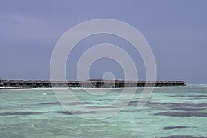 Some water villas in shallow blue seas of Maldives.