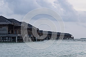 Some water villas in shallow blue seas of Maldives.