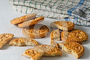 Some whole and broken coconut-flavored round biscuits and a napkin