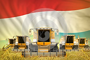 Some yellow farming combine harvesters on grain field with Luxembourg flag background - front view, stop starving concept -