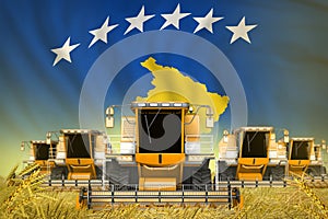 Some yellow farming combine harvesters on wheat field with Kosovo flag background - front view, stop starving concept - industrial