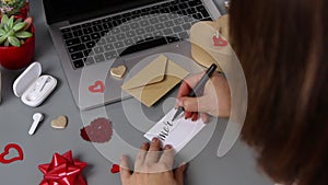 Somebody writing a card MARRY ME near valentine`s day gift