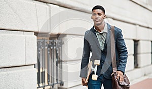 Someday isnt in the vocabulary of go getters. Shot of a young businessman holding a skateboard while walking through the