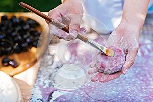 Someone is applying a brush to dough, likely preparing a dish in the kitchen.Mochi asian dessert