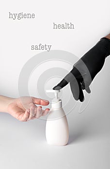 Someone in a black nitrile glove gives