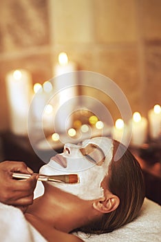 Someone busier than you is getting a facial right now. a young woman enjoying a facial treatment at the spa.