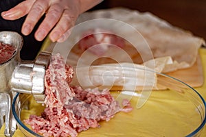 Someone is cooking minced meat with an manual meat grinder