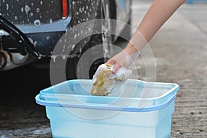 Someone hand catch sponge washing car door opener car.