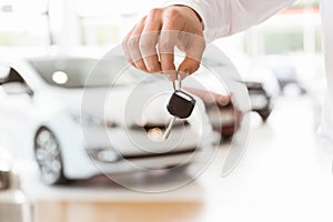 Someone holding car keys by his fingertips photo