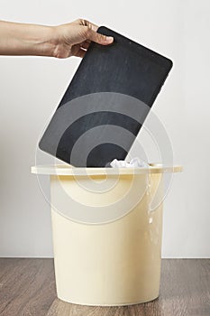 a person throwing a book into a bucket with tissues