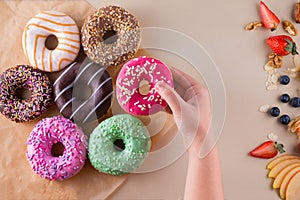 Someone`s hand holding sweet doughnut on light stone background