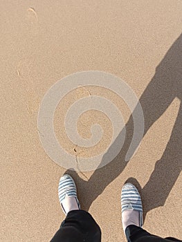 Someone stand on the beach and her shadow