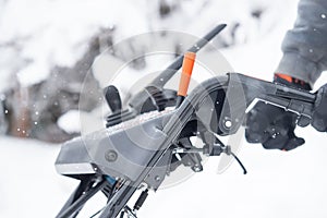 Someone uses a snowthrower outdoors in winter while it is snowing