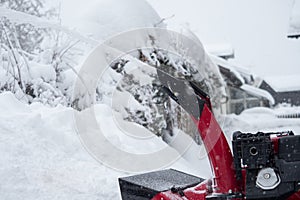 Someone uses a snowthrower outdoors in winter while it is snowing photo