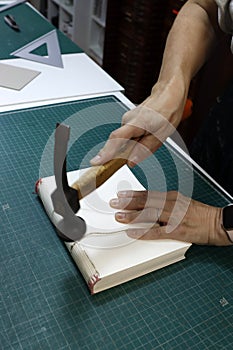 someone using a hammer to break through a piece of paper photo