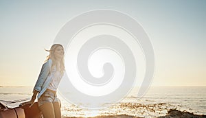 Sometimes all you need is a bit of fresh air. a young woman enjoying a road trip along the coast.