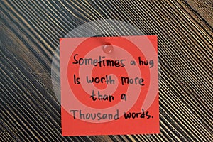 Sometimes a hug is worth more than a thousand words write on sticky notes isolated on Wooden Table. Motivation concept