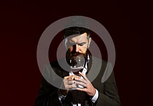 Sommelier with beard on burgundy background. Connoisseur with closed eyes