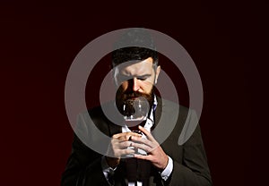 Sommelier with beard on burgundy background. Connoisseur with closed eyes photo