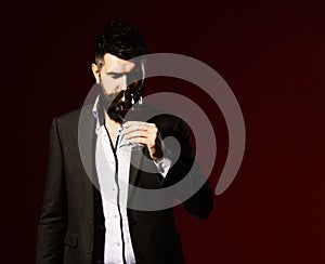Sommelier with beard on burgundy background. Degustation and winetasting concept photo