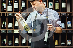 Sommelier choosing between two bottles of red and white wine