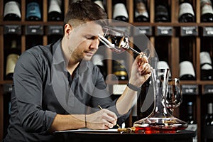 Sommelier degustating red wine poured in glass