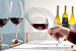 Sommelier evaluating red wine at wine tasting.