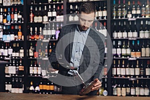 Sommelier man pours red wine into decanter for aeration of taste and aroma