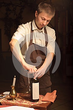 A sommelier opening wine bottle