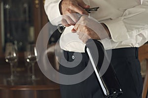 Sommelier opening wine bottle