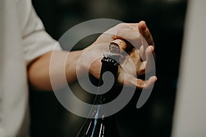 Sommelier opening wine bottle in the wine cellar