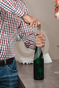 Sommelier Opening a wine bottle with corkscrew in a bar