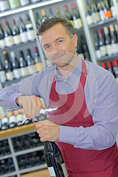 Sommelier opening wine bottle in wine cellar