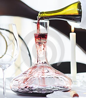 A sommelier pouring red wine into decanter