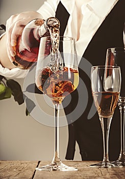 Sommelier pouring rose wine into glass at wine tasting in winery, bar or restaurant. White background photo