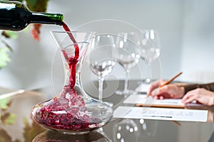 Sommelier pouring wine into decanter.