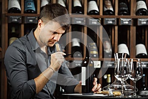 Sommelier reading label of bottle sniffing cork