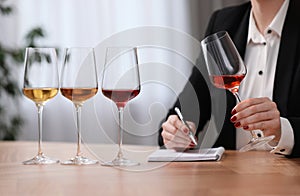 Sommelier tasting different sorts of wine at table indoors, closeup