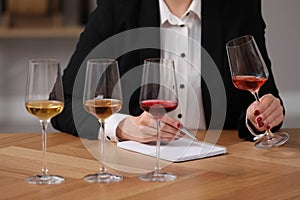 Sommelier tasting different sorts of wine at table indoors, closeup