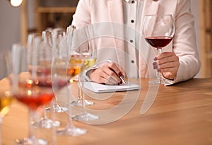 Sommelier tasting different sorts of wine at table indoors, closeup