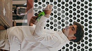 Sommelier uncorking wine bottle preparing degustation in winery cellar vertical