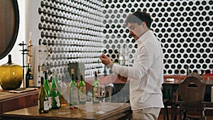 Sommelier uncorking wine bottle preparing to degustation in winery cellar.