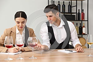 Sommeliers tasting different sorts of wine at table