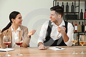 Sommeliers tasting different sorts of wine at table indoors