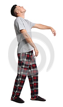 Somnambulist in pajamas on white background. Sleepwalking